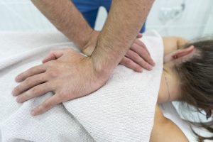 кинезитерапевт извършва техники за облекчаване при болки в гърба